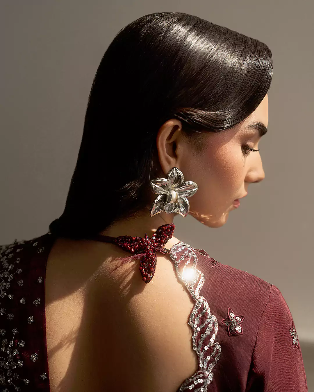 Fashion model in graceful stance wearing Sirra Formals collection with soft lighting