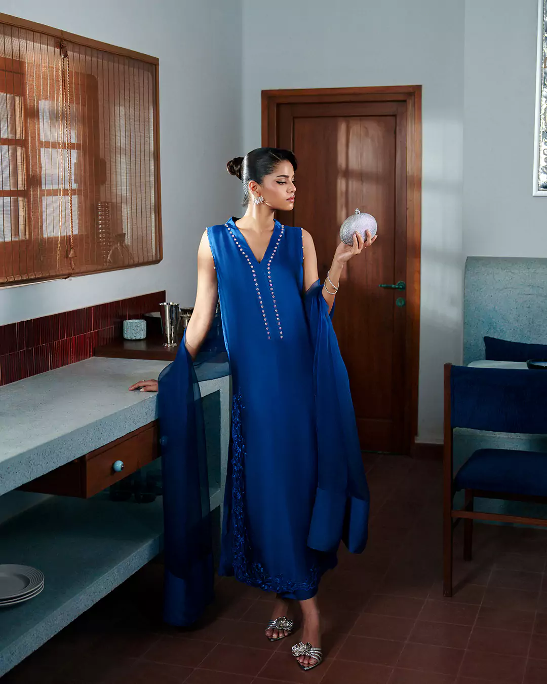 KALZARII 2026 formalwear campaign featuring a model in a blue outfit photographed in an elegant interior