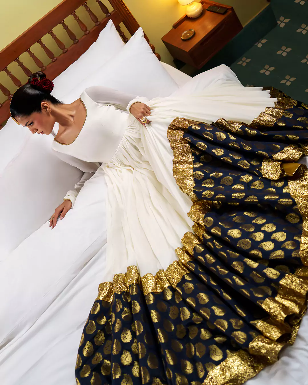KALZARII 2026 fashion campaign featuring a white formal outfit paired with a black and gold patterned drape